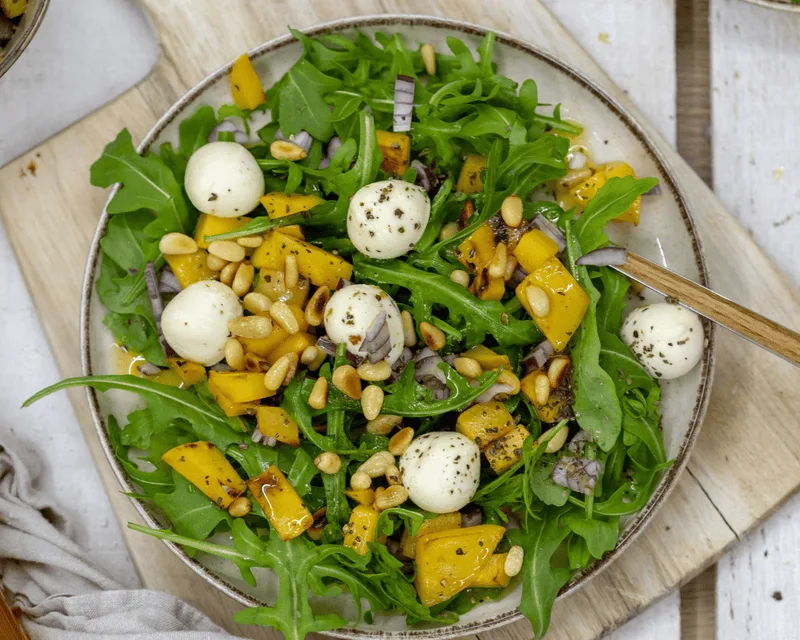 Rucolasalat mit gegrillter Mango und gerösteten Pinienkernen